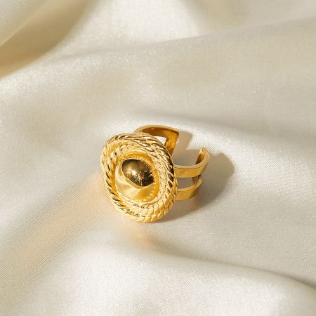 Detailed view of a gold ring with a textured border and a smooth central sphere.