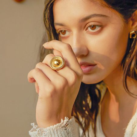 Another ring from the set, highlighting a rope-like texture surrounding a central gold ball.