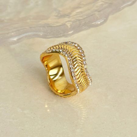 Another perspective of the gold ring highlighting its distinctive wavy design and embellishments.