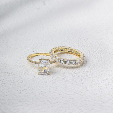 The complete 2-piece gold-plated engagement ring and eternity band set displayed together.