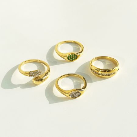 An assortment of four micro pave zircon oval signet rings from the set, showing different designs.