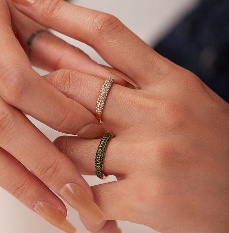 Close-up of two gold layered rings, one with white and one with green cubic zirconia stones.