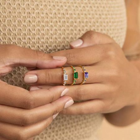 Three 925 sterling silver baguette CZ rings in white, green, and purple gemstone options, displayed side-by-side.
