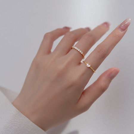 Gold version of the butterfly and heart CZ friendship ring set modeled on a hand.
