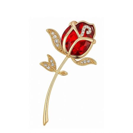 Classic gold rose brooch featuring a central red gemstone.