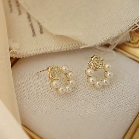 The set of five gold rose pearl earrings presented in an elegant gift box.