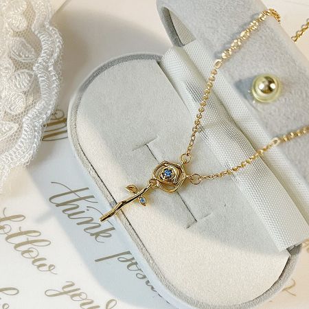 Fashion Gold Plated Zirconia Rose Flower Pendant Necklaces (Set of 5) - A stunning gold-plated rose flower pendant necklace with blue zirconia, part of a set of five, elegantly displayed on a white bust.