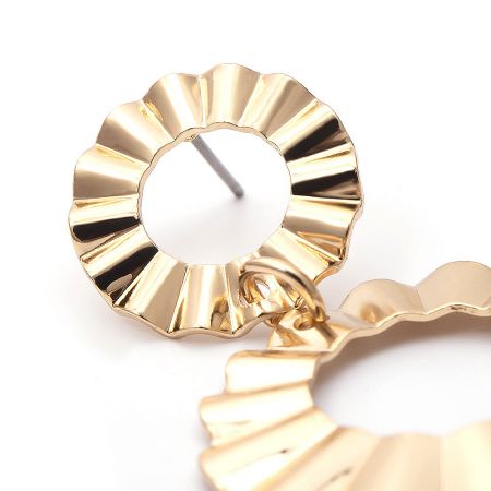 Close-up showing the ruffled circular texture of the elegant long earrings.