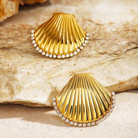 A pair of the gold-plated seashell earrings displayed to show their brilliant shine and intricate design.
