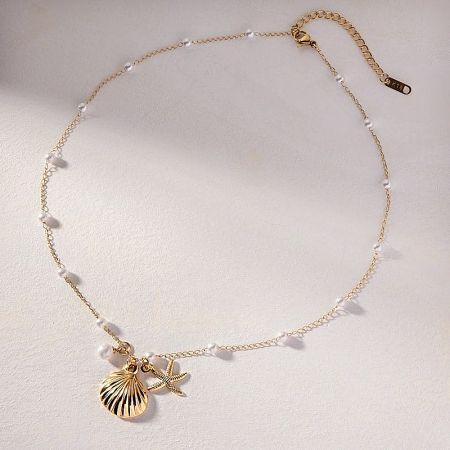 Full view of the gold seashell and starfish necklace, highlighting the small white beads on the chain.