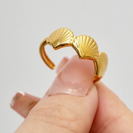 Close-up of the gold shell ring, showcasing its detailed design.