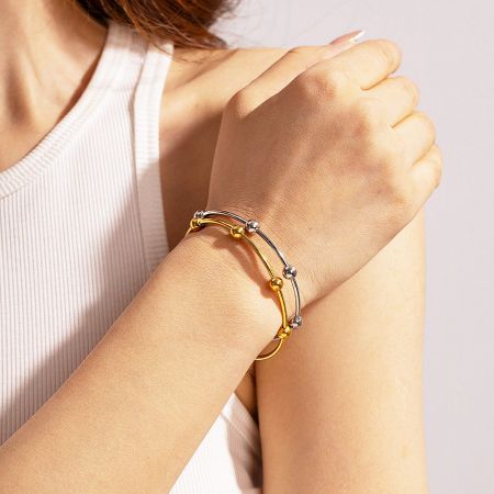 Top-down view of the gold and silver stainless steel bangle set.