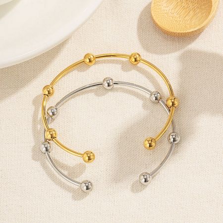 Close-up of the gold and silver stainless steel beaded cuff bangles.