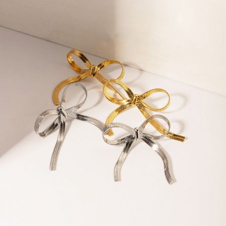 Stainless Steel Flat Snake Chain Bow Earrings (Set of 5 Pairs) - A pair of gold and a pair of silver stainless steel flat snake chain bow earrings displayed on a clean white background, showcasing their intricate design.