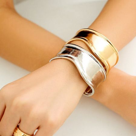 Brass Punk Wide Open Cuff Armband Bangle Bracelets - Set of 5 - A model's wrist adorned with a stack of gold and silver brass punk-style wide open cuff bracelets.