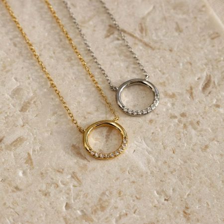 Close-up of the sterling silver round pendant necklace, available in both platinum plated and gold tone finishes.