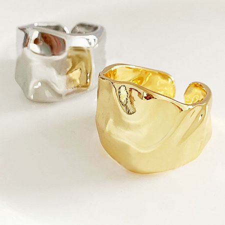 A pair of gold and silver hammered geometric open rings displayed together.