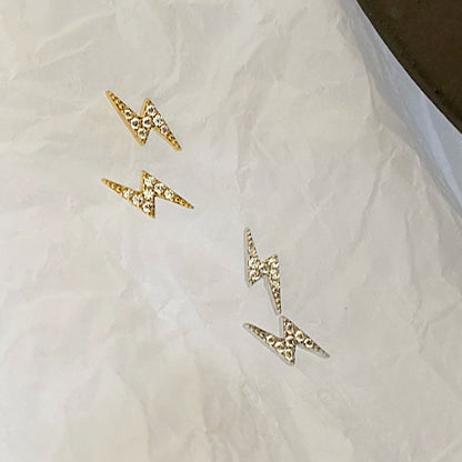 A collection of silver and gold lightning bolt earrings on display.