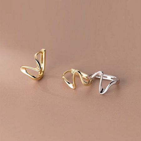 Both gold and silver options of the S925 minimalist wave cuff earrings displayed together.