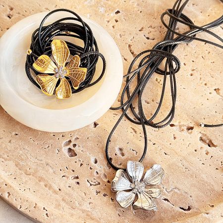 Stainless Steel 3D Hibiscus Flower Pendant Leather Necklaces (Set of 5) - A set of stainless steel 3D hibiscus flower pendant necklaces, showcasing both the gold and silver options on a neutral background.
