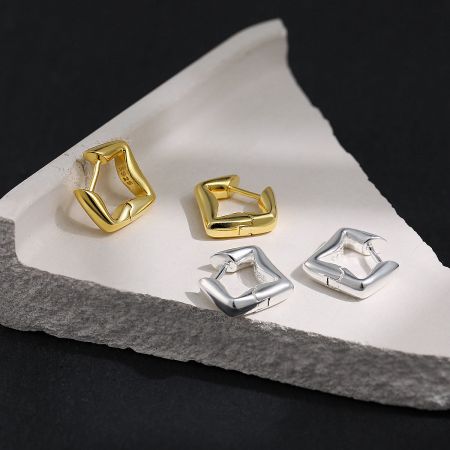Orecchini a cerchio geometrici in oro placcato, argento 925, all'ingrosso. - Un paio di orecchini a cerchio geometrici moderni disponibili sia in finitura placcata in oro 18K che in argento sterling 925, esposti affiancati su uno sfondo bianco pulito.