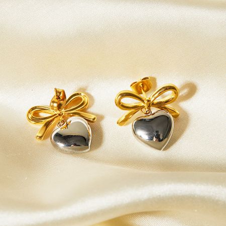 A pair of two-tone heart-shaped earrings with gold bows and silver hearts.