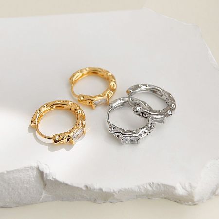 View of the gold and silver huggie earrings showing the hinged clasp.