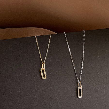 A stylish shot of the gold and silver oval pendant charms, highlighting their brilliant CZ stones.