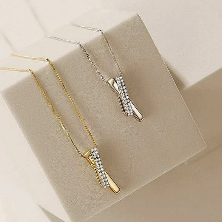 Top-down view of the interlocking pave CZ necklaces in gold and silver.