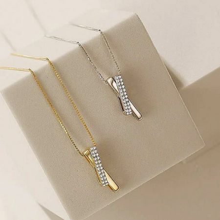 925 Sterling Silver Cross Necklace - A 925 Sterling Silver Cross Necklace shown in both silver and gold finishes, adorned with brilliant cubic zirconia stones.