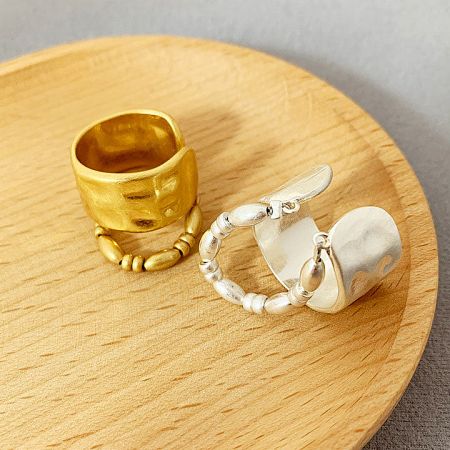 Top-down view of the gold and silver two-layered brass rings on a wooden display.