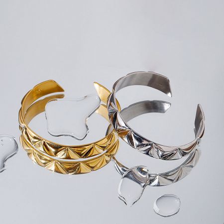 The durable, water-resistant finish of the gold and silver rippled design bracelets.