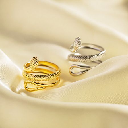 Stainless Steel Tarnish-Free Snake Curves Wrap Resizable Rings Set of 5 - A set of gold and silver stainless steel rings with an intricate snake curve wrap design, displayed on a luxurious satin fabric. Part of a tarnish-free, resizable ring collection.