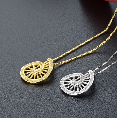 Gold and silver variations of the spinning necklace pendant, highlighting the spiral design and stone settings.