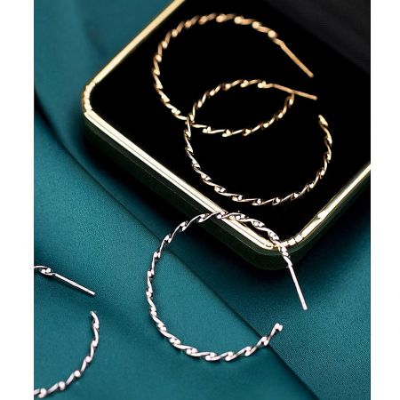 Gold and silver twist rope earrings displayed on a luxurious black velvet tray.