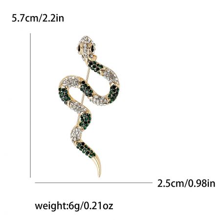 A detailed shot of the gold snake brooch featuring striking green gemstone eyes.