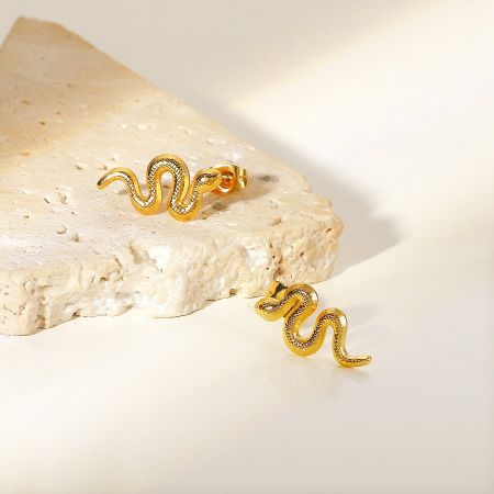 Promotional shot of the gold snake-shaped earrings.
