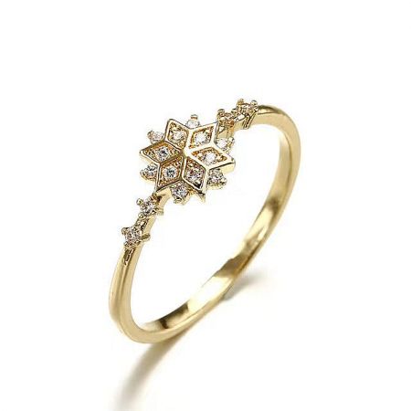 A close-up view of the gold snowflake ring, highlighting the detailed craftsmanship and the clarity of the gemstones.