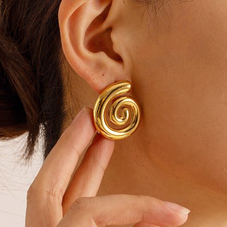Close-up of the gold spiral earring being worn, showcasing its elegant design.