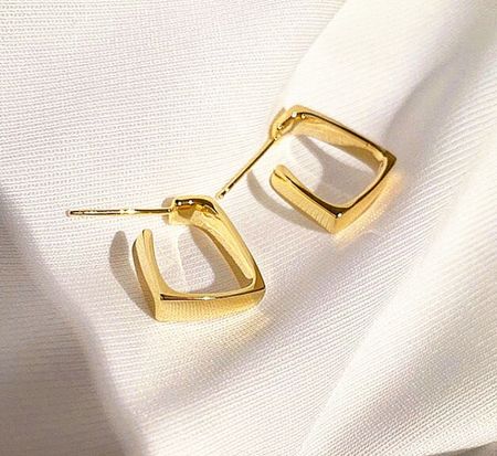 Detailed view of the gold square hoop earrings showcasing their smooth, polished surface.