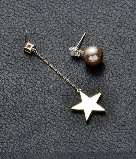 Detailed view of the Star Pearl Link Chain Earrings, highlighting the dangling gold star and the separate pearl stud.