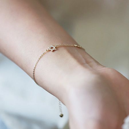 Clean product shot of the gold star bracelet on a white background, highlighting its polished finish.