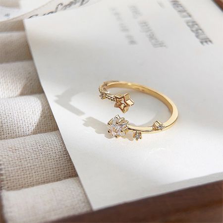 Close-up of a gold-plated ring with a unique star and diamond design.