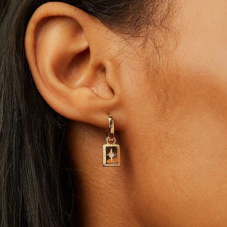 Close-up of the gold variant of the celestial square charm dangle earring, highlighting the star design.