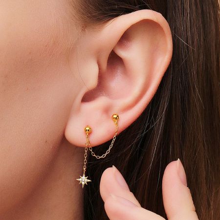 Close-up of the gold star pendant earring showcasing its detailed craftsmanship.