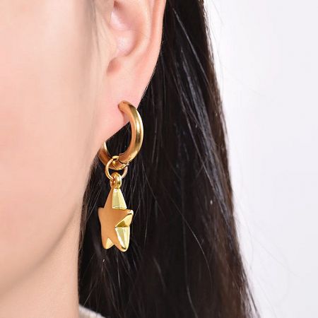 A close-up of the gold star earring, emphasizing its craftsmanship.