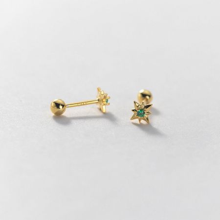 A pair of gold star-shaped earrings highlighting a rich green gemstone.
