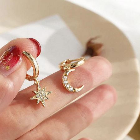 Orecchini a cerchio asimmetrici vintage in argento sterling 925 a forma di stella e luna (set di 5) - Un paio di orecchini a cerchio asimmetrici vintage in argento sterling 925 con placcatura in oro, caratterizzati da un charm a forma di stella e luna crescente adornato con gemme trasparenti scintillanti.