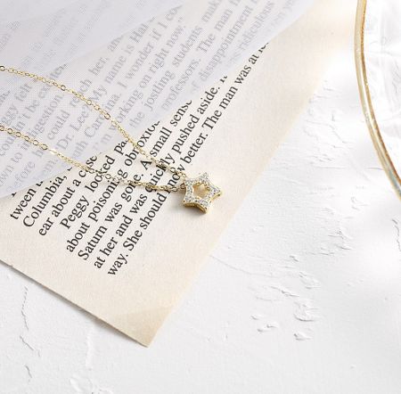Angled view of the gold-plated star pendant, emphasizing the sparkle of the clear cubic zirconia stones.