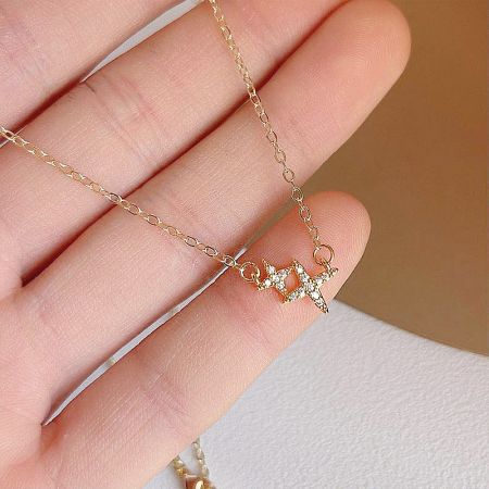 Close-up of the zirconia double-star pendant held in hand to show detail.